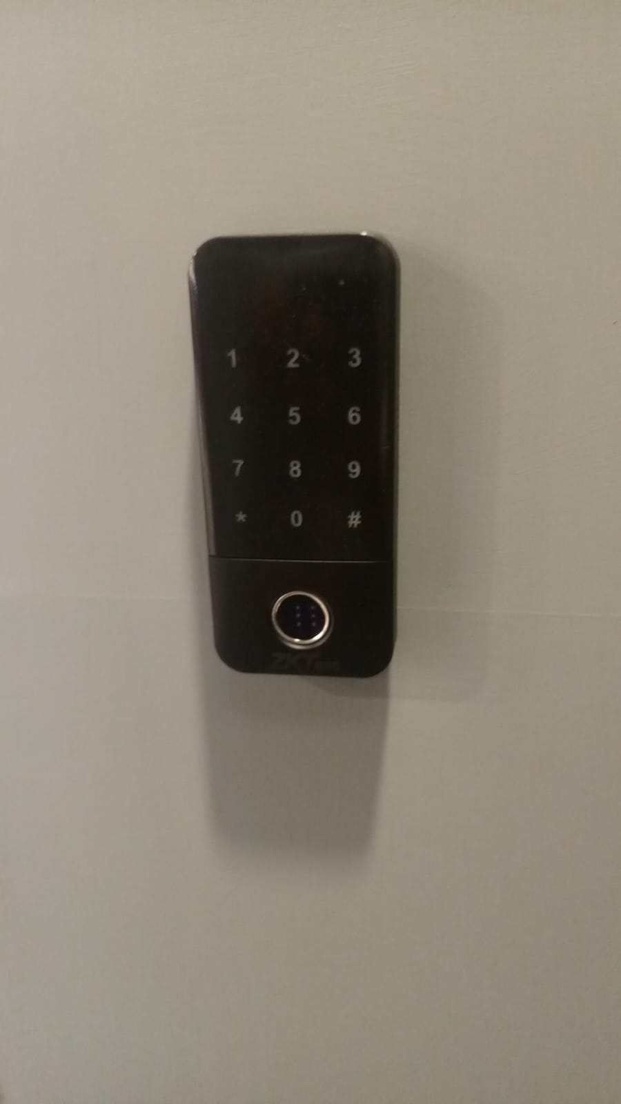 ZKTeco X3 fingerprint and touch keypad terminal mounted beside the door